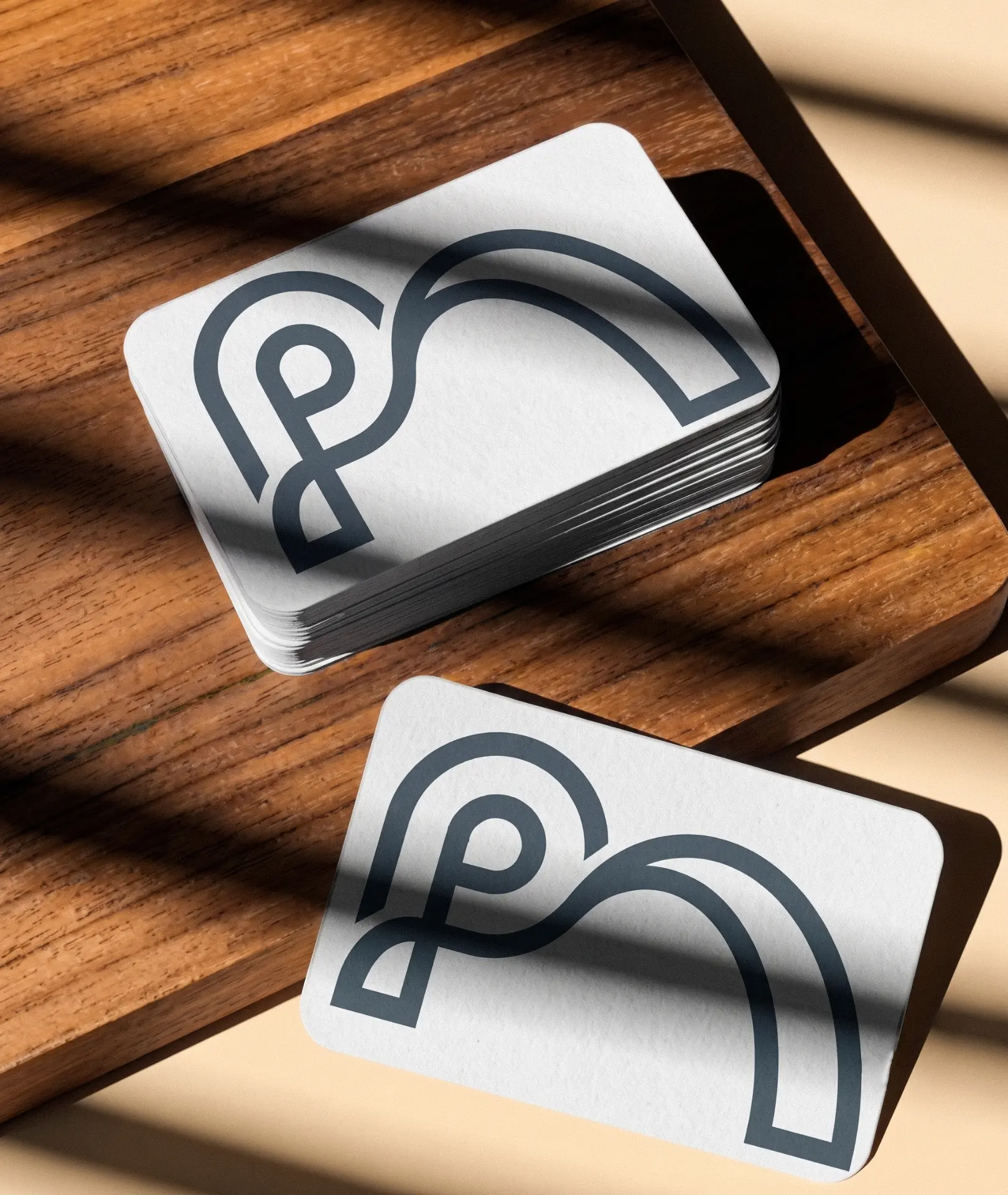 Praxis Assist business cards stacked in a walnut tray